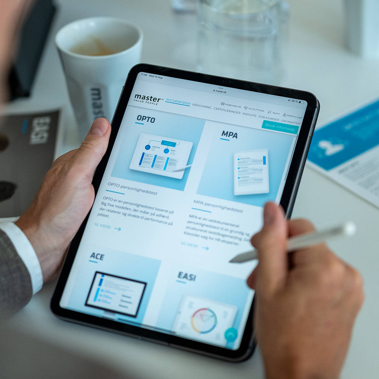 Eine Person nutzt ein Tablet mit Master Ch-Website in einem modernen Büro.