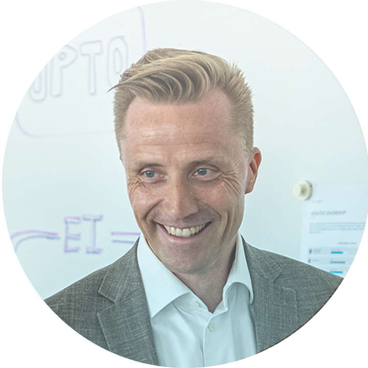 Ein lächelnder Mann in Anzug vor einem Whiteboard, Master Ch Präsentation.