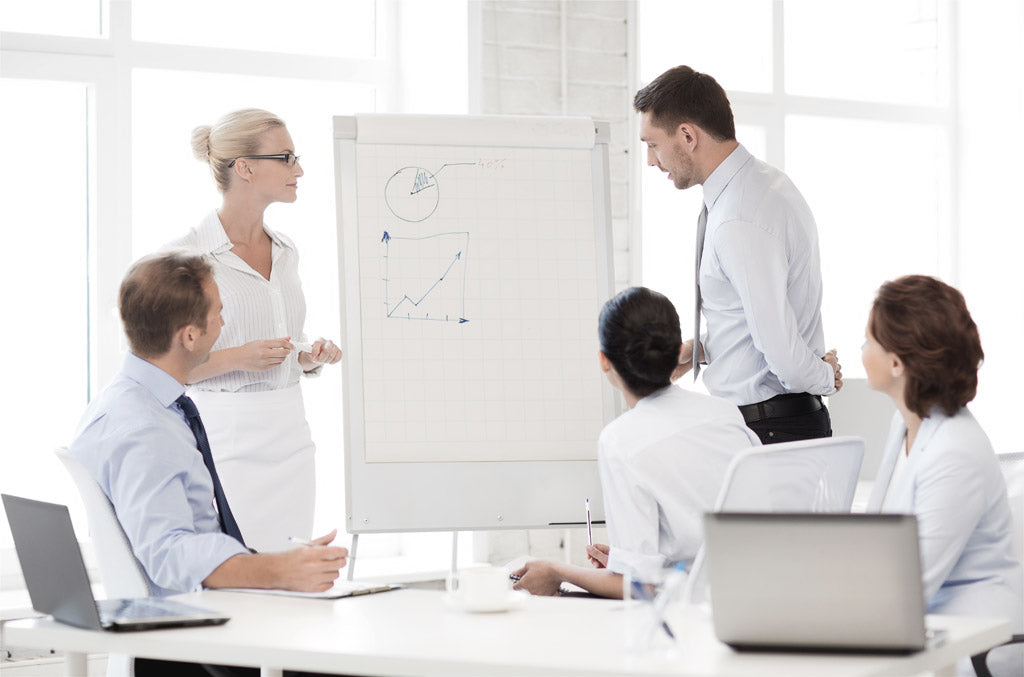 Eine Geschäftspräsentation mit fünf Personen vor einem Flipchart von Master Ch.
